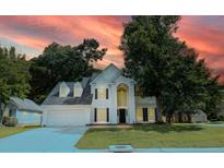 Charming two-story home featuring a well-maintained lawn, attached garage, and traditional architectural details at 407 Thomaston Ave, Summerville, SC 29485