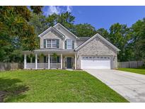 Charming two-story home with a brick facade, covered porch, and well-manicured lawn, offering curb appeal at 5105 Parrum Ct, Summerville, SC 29485
