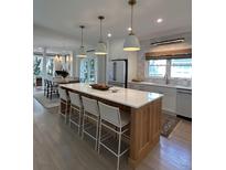 Bright kitchen features a large island with seating, pendant lighting, and stainless steel appliances at 578 Island Walk East, Mount Pleasant, SC 29464