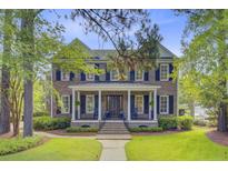 Traditional brick home with black shutters, a covered porch, and mature landscaping at 750 Navigators Run, Mount Pleasant, SC 29464