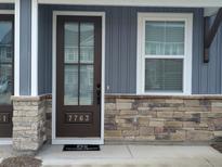 Charming entryway featuring a brown front door, stone accents, and a small window at 7763 Park Gate Dr, North Charleston, SC 29418