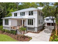 Beautiful two-story home with a metal roof, a garage, and mature landscaping at 8187 Jack Island Dr, Johns Island, SC 29455