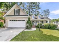 Charming home featuring a two-car garage, landscaped front yard, and a welcoming porch at 8618 Woodland Walk, North Charleston, SC 29420