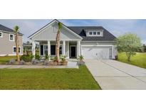 Charming single-Gathering home featuring a welcoming front porch, well-manicured lawn, and attached garage at 1035 Tea Time Dr, Summerville, SC 29485