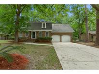Charming brick home features a two-car garage and mature trees surrounding the property at 105 Spring St, Summerville, SC 29485