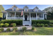 Charming home featuring a welcoming front porch, dormer windows, and mature landscaping at 1173 Penny Creek Dr, Ruffin, SC 29475