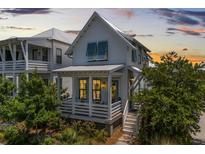 Charming two-story home featuring a welcoming porch, light blue shutters, and lush landscaping at 1466 Mizzen Aly, Johns Island, SC 29455