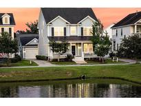 Charming two-story home with a well-manicured lawn and a pond in the front yard, perfect for suburban living at 1601 Bourne Xing, Mount Pleasant, SC 29466