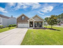 Charming brick home featuring an attached garage, inviting front porch, and a well-manicured front lawn at 201 Maywood Dr, Moncks Corner, SC 29461