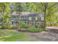 Charming two-story home with brick and siding exterior, surrounded by mature trees and landscaping at 303 High Grove Rd, Summerville, SC 29485