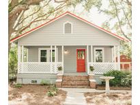 Charming single-story home featuring a cozy front porch, red door, and mature trees at 317 Bay St, Walterboro, SC 29488