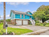 Eye-catching two-story teal home with a two-car garage, solar panels, and well-maintained landscaping at 4636 Ashley View Ln, North Charleston, SC 29405