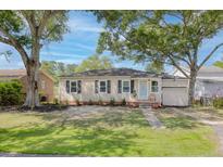 Charming single-story home with a well-manicured lawn and mature trees, offering curb appeal at 5904 Oak Street, Hanahan, SC 29410