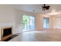 Bright living room features fireplace, wood floors, and access to a screened deck at 6275 Rolling Fork Rd # 401, North Charleston, SC 29406