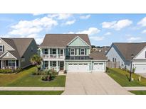 Inviting two-story home with a charming front porch, landscaped lawn and a two car garage at 658 Yellow Leaf Ln, Summerville, SC 29486