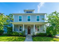 Charming two-story home with a welcoming front porch, well-manicured lawn, and blue horizontal siding at 72 Crossandra Ave, Summerville, SC 29483