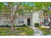 Charming two-story condo with white siding, a walkway, mature trees, and a private second-story balcony at 7814 Nummie Ct, North Charleston, SC 29418