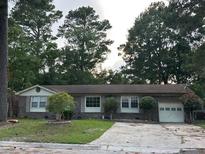 Charming single-story home with brick facade, landscaped front yard, and attached garage at 8334 Witsell St, North Charleston, SC 29406
