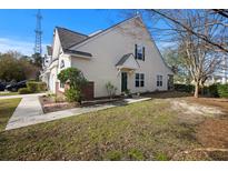 Charming townhome with light yellow siding, manicured landscaping, and inviting entryway at 1005 Yellow Hawthorn Circle, Summerville, SC 29483