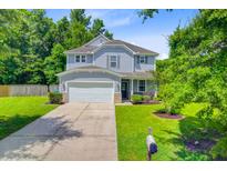Charming two-story home boasts a well-manicured lawn, attached two-car garage, and a welcoming front porch at 104 Study Ct, Ladson, SC 29456