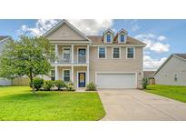 Charming two-story home featuring a welcoming front porch, attached two-car garage, and well-manicured lawn at 109 Cypress Plantation Rd, Moncks Corner, SC 29461