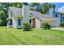 Charming single-Gathering home features a manicured lawn and attached two-car garage at 112 Lewisfield Dr, North Charleston, SC 29418