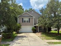 Charming two-story home featuring a two-car garage and a cozy front yard surrounded by mature trees at 112 Malibu Rd, Summerville, SC 29483