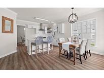Well-lit kitchen featuring white cabinets, stainless steel appliances, and stylish dining area with a wooden table at 113 Amaranth Ave, Summerville, SC 29483