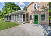 Inviting home exterior featuring a screened porch, a bright green front door, and neutral siding at 113 Harvey Ave, Goose Creek, SC 29445