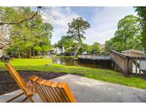 View of a neighborhood swimming pool with lounge chairs and wooden bridge in a landscaped community at 1136 Shadow Lake Cir, Mount Pleasant, SC 29464