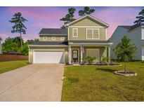 Charming two-story home with a well-manicured lawn, inviting curb appeal, and an attached two-car garage at 119 Lucca Dr, Summerville, SC 29486