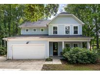 Charming light blue two-story home featuring a two-car garage and welcoming front porch at 1216 Ashley Hall Rd, Charleston, SC 29407