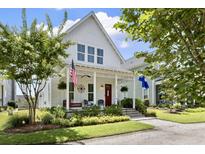 Charming white two-story home with inviting front porch, decorative elements, and well-manicured landscaping at 132 Clear Bend Ln, Summerville, SC 29486