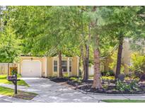 Charming home with a well-manicured lawn and mature trees shading the front yard and driveway at 1350 Water Edge Dr, Charleston, SC 29492