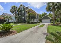 Inviting two-story home featuring a spacious driveway, lush landscaping, and a charming garage with matching paint at 136 Heart Pine Cir, Summerville, SC 29485