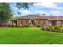 Charming brick home with manicured lawn, red shutters, and mature landscaping provides curb appeal at 1551 Hutton Pl, Charleston, SC 29407