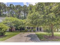 Charming single Gathering home with a well maintained front yard, mature trees, and a long driveway at 2136 Kings Gate Ln, Mount Pleasant, SC 29466
