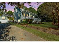 Charming two-story home with a spacious front porch and well-manicured lawn, perfect for outdoor living at 406 S Gum St, Summerville, SC 29483