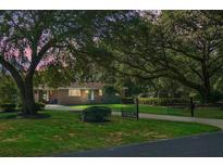 Charming brick home with lush front lawn, mature trees, and gated driveway at 4428 Maple Ridge Rd, Walterboro, SC 29488