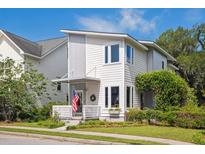 Charming two-story home with a modern design, landscaped yard, and inviting front porch perfect for enjoying the outdoors at 5017 W Liberty Park Cir, North Charleston, SC 29405
