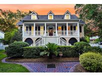 Charming two-story home with a inviting front porch, manicured landscaping and a brick path at 512 Whilden St, Mount Pleasant, SC 29464