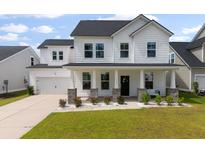 Charming two-story home featuring a white exterior, black roof, covered front porch, and well-manicured lawn at 513 Richfield Way, Summerville, SC 29486