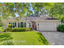 Charming single-story home with manicured lawn, beautiful landscaping, and a two-car garage at 5406 E Crosland Ct, North Charleston, SC 29420