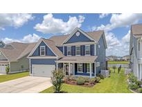 Charming two-story home with blue siding, black shutters, a front-facing two-car garage, and a well-manicured lawn at 602 Yellow Leaf Ln, Summerville, SC 29486
