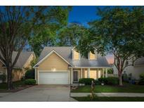 Charming home with a well-manicured lawn, mature trees, and a welcoming two-car garage at 708 Lawton Harbor Dr, Charleston, SC 29412