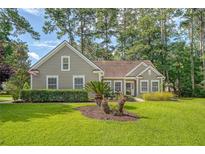 Charming single-story home with a well-manicured lawn and mature trees at 801 Long Drive Rd, Summerville, SC 29485