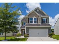 Charming two-story home featuring a well-maintained lawn and attached two-car garage at 9680 Spencer Woods Rd, Ladson, SC 29456