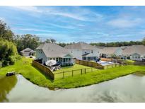 Expansive backyard features lush green grass, a charming patio set, and a relaxing swimming pool, all fenced in at 105 Plowden Mill Ct, Summerville, SC 29485