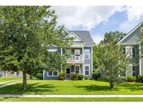 Charming two-story home featuring a double balcony, tidy lawn, and mature shade trees at 1070 Moss Grove Dr, Moncks Corner, SC 29461