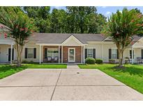 Charming single-story home with a brick and siding facade, well-manicured lawn, and flowering trees at 122 Stewart Pl, Summerville, SC 29485